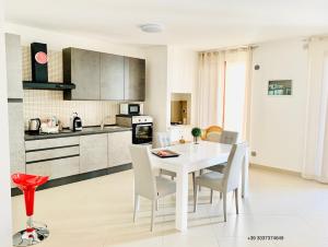 a kitchen and dining room with a white table and chairs at Dimora Anvi - Relax Fronte Mare in Polignano a Mare +64 photos