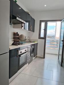 a kitchen with a stove and a washing machine at Appartement Moderne à CABO Huerto Del Rio in Cabo Negro