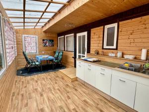 a kitchen with a table and chairs in a room at Bungalowdorf Briesensee in Neu Zauche