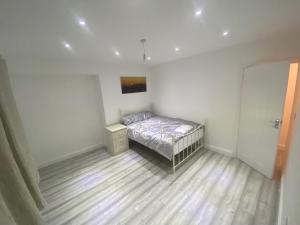a small bedroom with a bed and a wooden floor at 3 Bedroom House- Loughborough-Sleeps 5-FreeParking in Loughborough