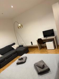 a living room with a black couch and a desk at Roiano Cinque in Trieste