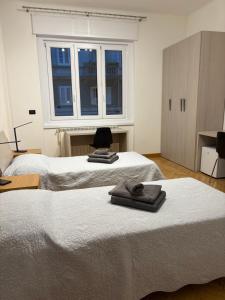 two beds in a room with a window at Roiano Cinque in Trieste