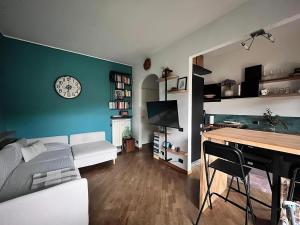 a living room with a white couch and a clock on a wall at AliRiHome in Rapallo