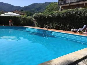 a swimming pool with blue water in front of a house at AliRiHome in Rapallo