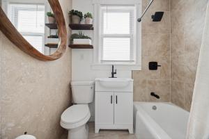 a bathroom with a toilet and a sink and a mirror at Spacious & Stylish 2BR Apartment Near Manhattan in Jersey City +9 photos