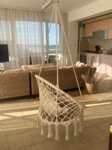 a hanging hammock in a living room with at Voyage Apartment Mamaia in Mamaia