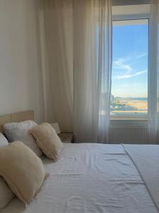 a bedroom with a bed with pillows and a window at Voyage Apartment Mamaia in Mamaia