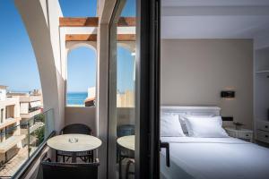 a bedroom with a bed and a view of the ocean at Georgia's Garden by Omilos Hotels in Amoudara Herakliou