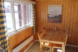 a wooden table and chairs in a room with a window at Fjellstova Ørskogfjellet Cottages in Sjøholt