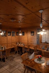 a restaurant with wooden walls and tables and chairs at Kirchsteigeralm in Hafling