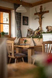 a dining room with a wooden table and chairs at Kirchsteigeralm in Hafling