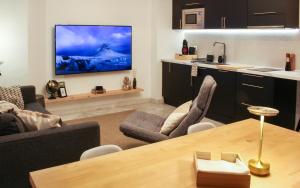 a living room with a television on a wall at Casa Kiwi in Algeciras