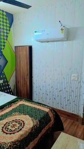 a bedroom with a bed and a light on the wall at Hotel paris in Mohali