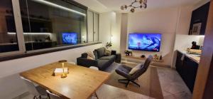 a living room with a table and a tv at Casa Kiwi in Algeciras