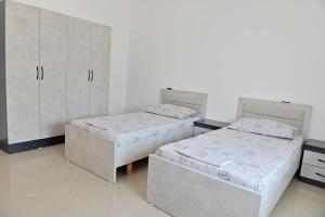 a room with two beds and a cabinet at Ferienhaus Qelia in Durrës