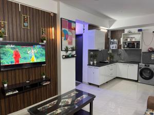 a living room with a tv on a wall at Dwarka Express Studios in Gurgaon