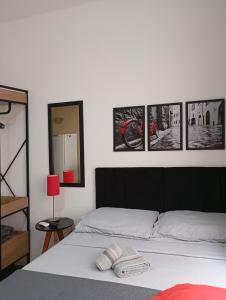 ein Schlafzimmer mit einem Bett mit vier Bildern an der Wand in der Unterkunft Estúdio na melhor rua do Centro Histórico, bem localizado in Porto Alegre