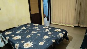 a bed with a blue comforter with flowers on it at Rozarios Aparts, Kochi in Cochin