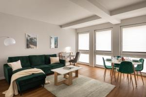 a living room with a green couch and a table at Trevi Apartments Tychy in Tychy