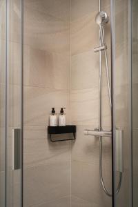 a bathroom with a shower with two bottles on a shelf at Trevi Apartments Tychy in Tychy +93 photos