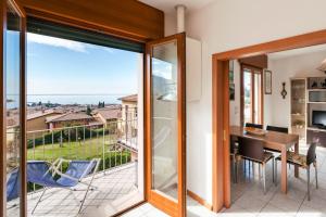 ガルダにあるTERRAZZA DI GARDA - Regarda Travelのテーブルと椅子のあるバルコニー付きの部屋