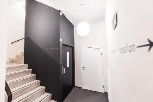 a hallway with stairs and a black wall at Göttfried - essen trinken schlafen in Linz