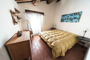 a bedroom with a bed and a table and a window at La Casetta di Zio Gino in Cingoli