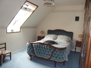 a bedroom with a bed with a blue couch at Chambres d'hôtes La Poudrière in Argentan