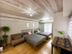 東京にあるBb渋谷区 新宿乘地下铁4分钟 西新宿五丁目步行8分钟のベッドとソファとテーブルのある寝室