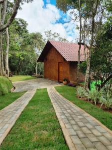a house with a brick driveway in front of it at Chalé HOSPEDAGEM in Rio Bananal