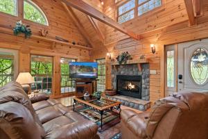 a living room with leather furniture and a fireplace at Elk Rapids on Cosby Creek in Cosby