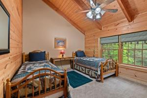 a bedroom with two beds and a ceiling fan at Elk Rapids on Cosby Creek in Cosby