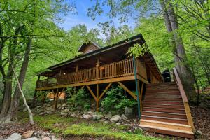 a tree house in the woods with a staircase at Elk Rapids on Cosby Creek in Cosby