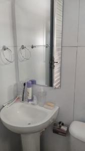 Casa Cida PARA SAO JOÃO في كاروارو: حمام أبيض مع حوض ومرآة