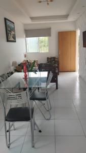 Casa Cida PARA SAO JOÃO في كاروارو: غرفة طعام مع طاولة وكراسي زجاجية +14 صورة