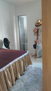 Casa Cida PARA SAO JOÃO في كاروارو: غرفة نوم بها سرير وسجادة وقبعة