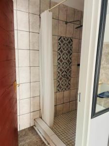 a shower with a shower curtain in a bathroom at Khainos Self Catering in Khomas Region