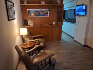 une salle d'attente avec des chaises, une table et une télévision dans l'établissement 4 Ventanales sobre la Avenida Corrientes, à Buenos Aires