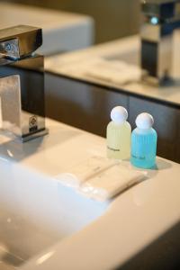 two bottles ofodorizers sitting on top of a bathroom sink at 6th Avenue Surin Beach - Official Account in Surin Beach