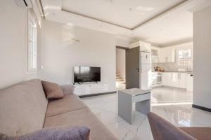 een woonkamer met een bank en een tv en een keuken bij Likya Karya Villaları in Koycegiz