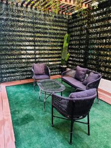 a patio with chairs and a table and a wall at Urban Garden Retreat Cozy Studio and Private Patio in Cairo
