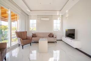 een woonkamer met een bank en een tv bij Likya Karya Villaları in Koycegiz