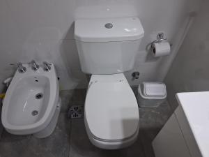 une salle de bain avec des toilettes blanches et un lavabo dans l'établissement 4 Ventanales sobre la Avenida Corrientes, à Buenos Aires 44 autres photos