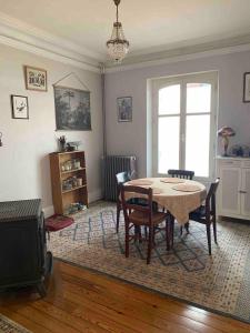 a dining room with a table and chairs and a tv at Chambres chez l'habitant - maison des années 30 in Troyes