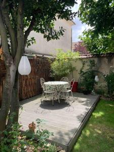 a table and chairs on a patio in a garden at Chambres chez l'habitant - maison des années 30 in Troyes