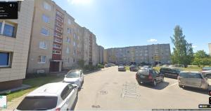 a group of cars parked on a street with buildings at Buto nuama in Mažeikiai
