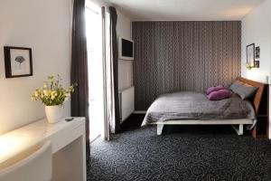 Aars Hotel في Års: غرفة نوم مع سرير مع وسائد أرجوانية عليه