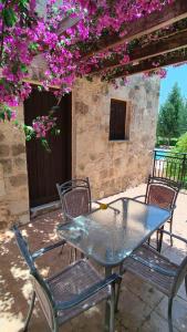 un tavolo e sedie su un patio con fiori viola di Villa Penelope a Douliana Altre 37 foto