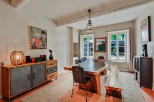 a living room with a table and a television at Prieuré Saint-Louis Maison d'Hôtes in Floure