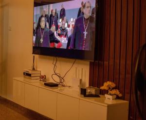 a flat screen tv hanging on a wall above a table at EFFAZ Apartments Airport Road Lugbe in Abuja